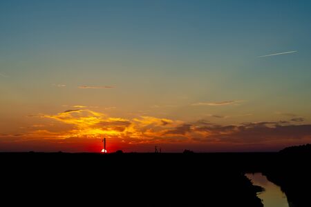 Evening sunset near the river and the plane flies.の写真素材