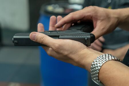 A hand of man practicing firing using a Glock gun model at the shooting range. Fire glock hand gun....