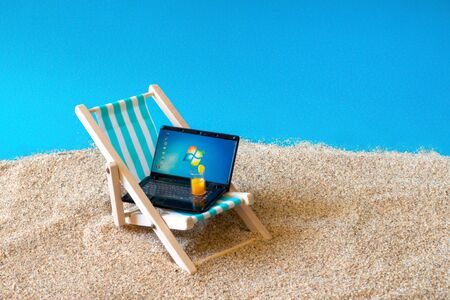 Sonys miniature laptop on a miniature blue deck chair. Freelance Part time Outsources Job Employment Concept. Work on travel. Russia, Tatarstan, September 05, 2019のeditorial素材
