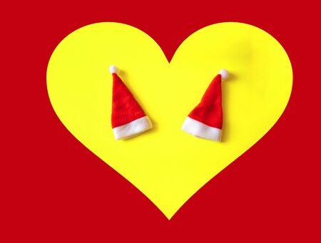 Two red Santa Claus hats in to the heart. The concept of love and the New Year and Christmas. Couple in love.の写真素材