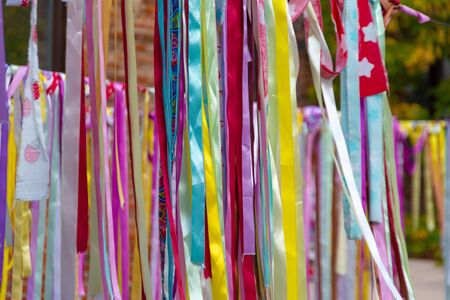 Multicolor bright ribbons hanging outdoors, can be used as a background or decorの写真素材