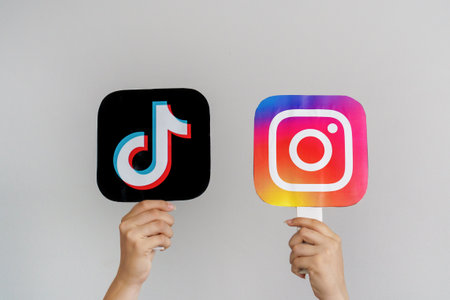 Girls Teen Hands Hold TikTok and Instagram logos on Gray background. Concept of Teenagers Using the Most Popular Social Networks. Turkey, Istanbul, September 17, 2024.のeditorial素材