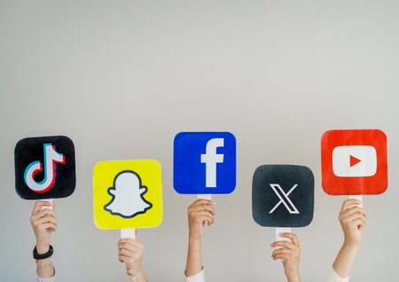 Teenagers hold signs with logos of famous and popular social networks around the world TikTok,...