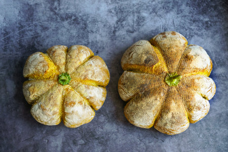 Top view Homemade sourdough bread in the shape of a pumpkin on a gray background. Autumn pumpkin bun.の写真素材