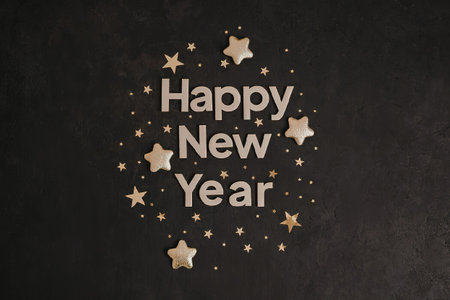 A dark background with gold stars and the words 'Happy New Year' in the center, surrounded by small...