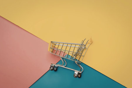 A small shopping cart on a vibrant background divided into yellow, pink, and blue sections.