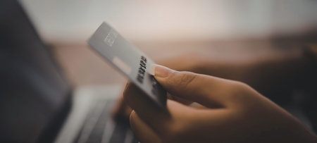 A close-up of a hand holding a credit card, likely for an online transaction.の写真素材