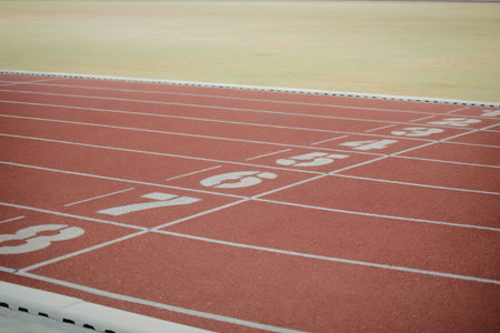 a red running track with white lines and numbersの写真素材
