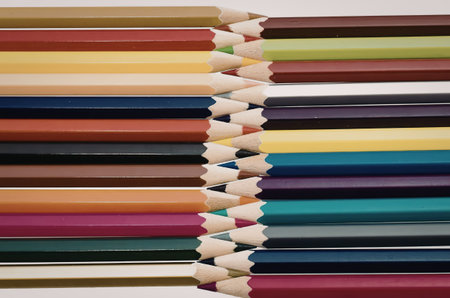 A set of vibrant colored pencils arranged in two rows on a white background, showcasing their...