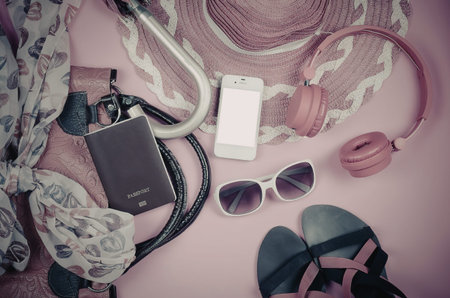 A collection of fashion accessories including a purse, phone, headphones, sunglasses, and sandals...