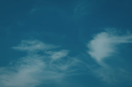 A bright blue sky with a few white clouds scattered across it.