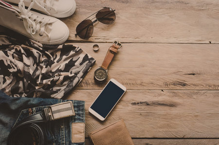 A collection of fashion items including shoes, sunglasses, watch, phone, and clothing laid on a...