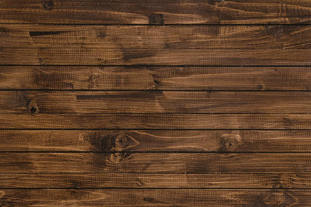 A close-up of dark brown wooden planks with visible knots and grain