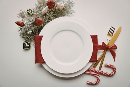 a white plate with red napkin and christmas decoration