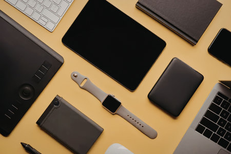 An overhead shot of various modern electronic devices such as smartphones, tablets, laptops,...