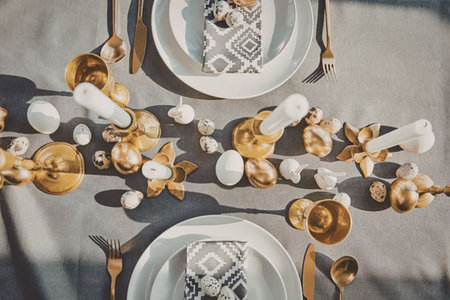 A beautifully set table with gold accents, white plates, and decorative elements