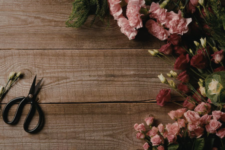 a bunch of flowers and a pair of scissors on a wooden table