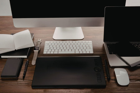A well-organized workspace for graphic designers with a computer, keyboard, mouse, drawing tablet,...