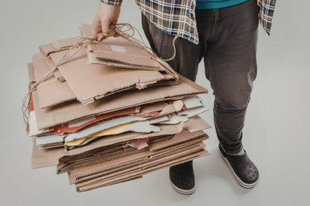 A person holding a large stack of papers tied with twine