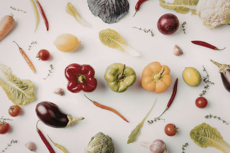 An assortment of colorful vegetables and fruits arranged on a white background