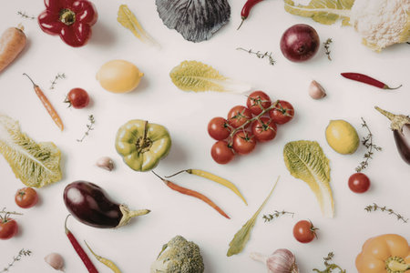 A colorful assortment of fresh vegetables and fruits arranged on a white surface
