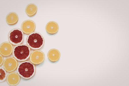 A collection of sliced citrus fruits, including oranges and grapefruits, arranged on a white background.の写真素材