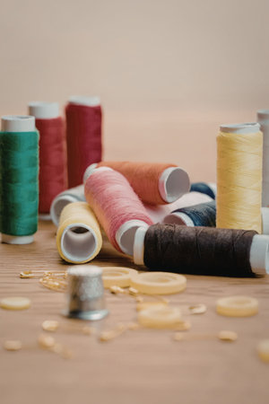 A collection of vibrant thread spools and buttons on a wooden surface