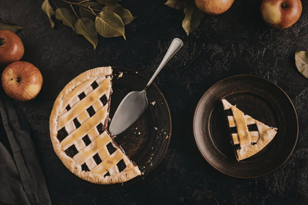A delicious homemade apple pie with a slice cut out and placed on a small plate, surrounded by...