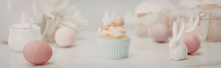 Easter decoration with bunny, eggs, and desserts on a white surface