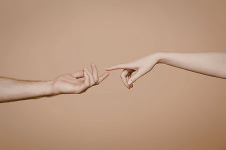 Two hands reaching out to touch each other with index fingers extended