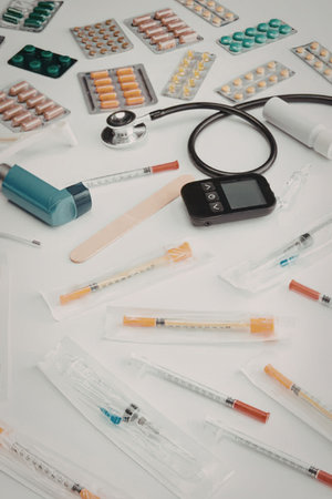 A collection of medical supplies for diabetes care, including syringes, pills, a stethoscope, and a...