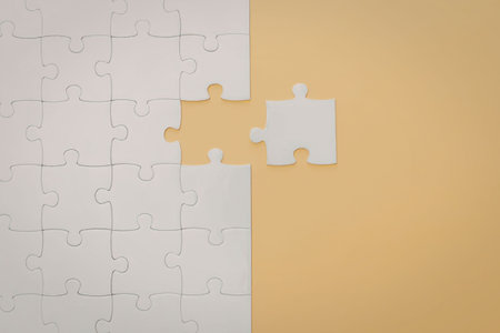 A jigsaw puzzle with two pieces fitting together on a yellow and white background