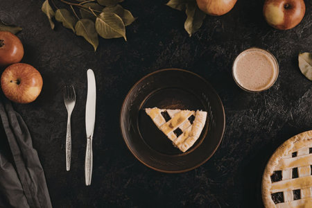 A slice of apple pie on a plate with a cup of coffee, surrounded by apples and a whole pie