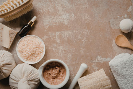 The image shows various spa products and tools arranged on a surface, including herbal poultices, bath salts, and a towel.の写真素材