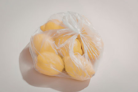 A plastic bag containing several fresh durian fruits on a plain backgroundの写真素材