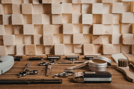 A wooden table with various tools and equipment, including a brush and other hardware, in front of a wooden wall.の写真素材