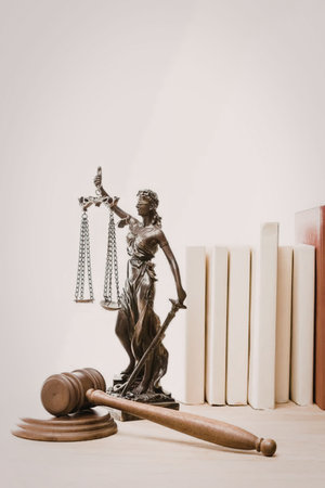 The image depicts a statue of justice with scales and a sword, accompanied by a gavel and books.