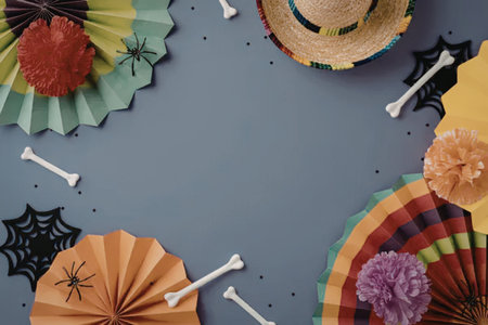 Vibrant paper fans, flowers, and bones on a purple background create a festive Dia de los Muertos...
