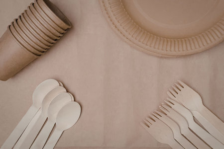 Biodegradable disposable tableware including cups, plates, spoons, and forks made from eco friendly materials for sustainable dining and outdoor events.の写真素材