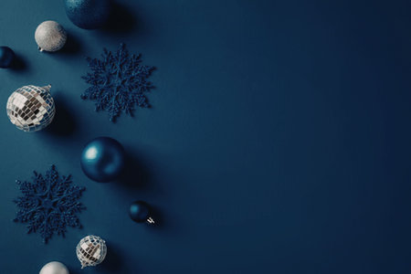 Blue christmas decorations including snowflakes and ornaments on a solid blue background create a festive holiday theme for greeting cards and winter celebrations.の写真素材