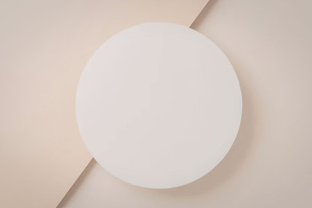 White circle on a two-tone soft yellow and beige background creating a minimalist and elegant abstract design perfect for various artistic and graphic uses.の写真素材