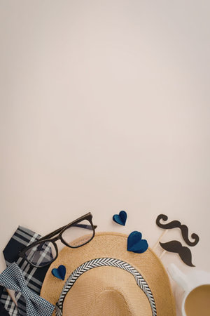Straw hat, sunglasses, blue hearts, and a mustache prop arranged with a coffee mug on a beige background, representing summer fashion essentials and a playful, stylish vibe.の写真素材