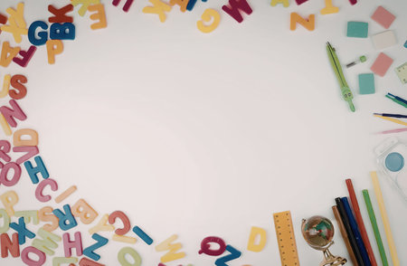 Bright and colorful alphabet letters with pencils, markers, and school items on white surface