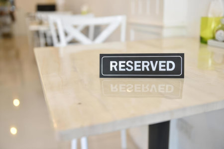 A reserved sign placed on a table in a clean, bright dining area with modern decor.