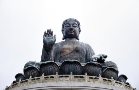 A big Buddha statue sitting on a platform outdoors with a cloudy sky in the background.