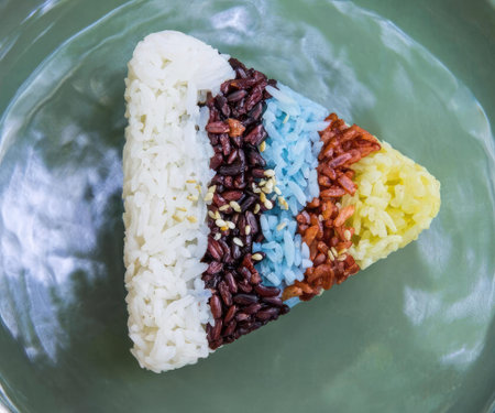 A rice cake decorated with various colorful toppings on a plate.