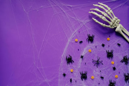A creepy skeleton hand surrounded by spiders and yellow dots on a purple background.