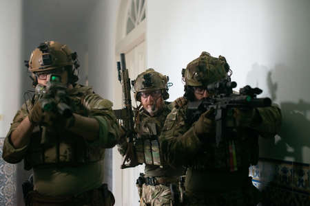 Focused men playing strikeball together. Men in military uniforms aiming, looking for enemies. Army,...