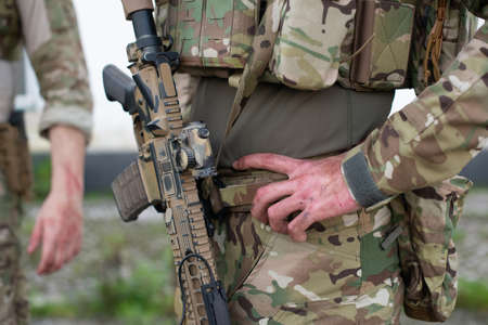 Close-up of man in military equipment outdoors. Man in uniform holding machine gun. Military, army, weapon airsoft conceptの写真素材