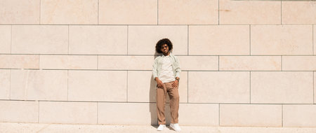 Glad Black man outdoors. African American man in casual clothes and sunglasses walking on sunny day. Portrait, city life conceptの写真素材